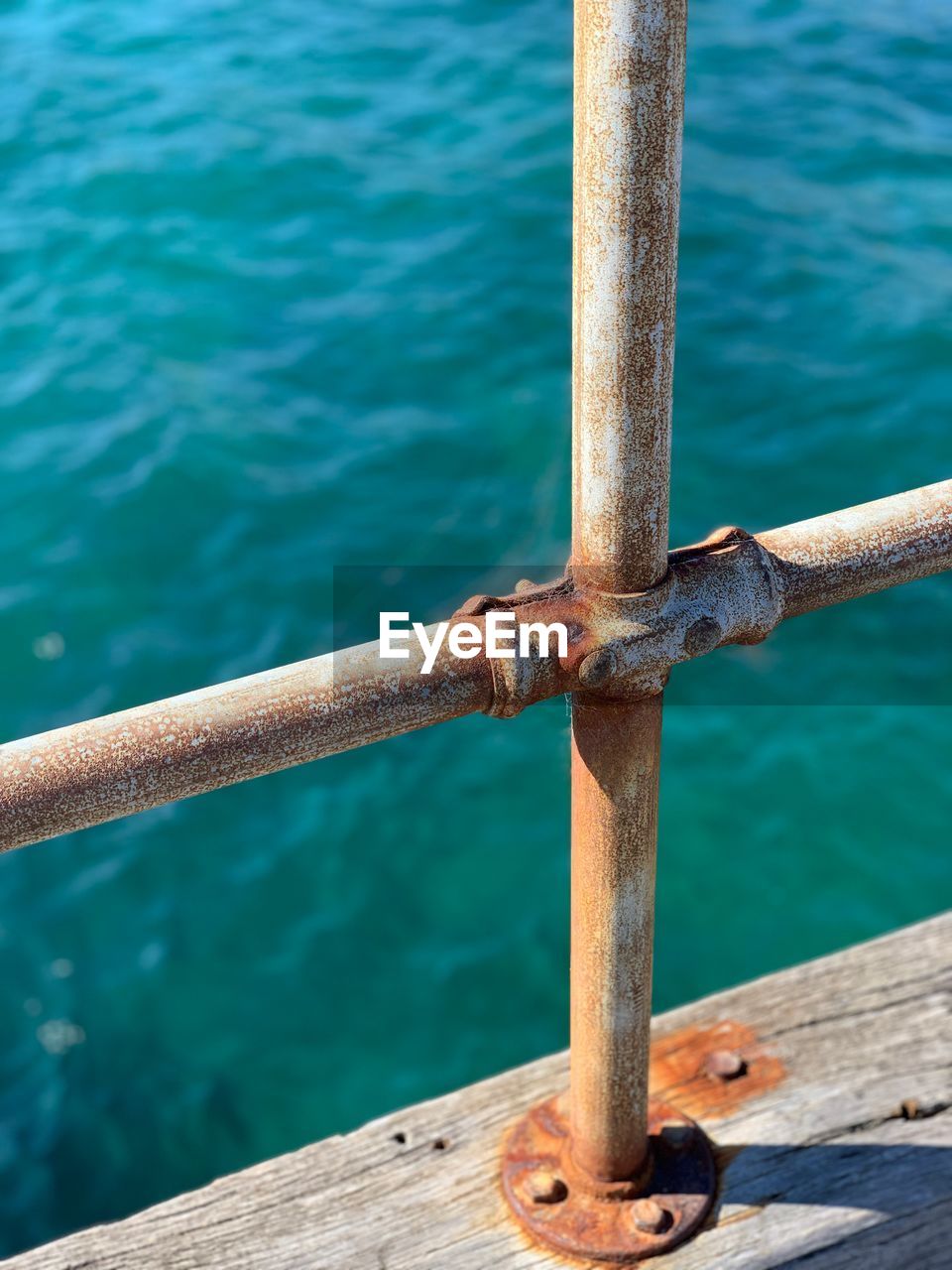 Close-up of rusty metal railing against sea