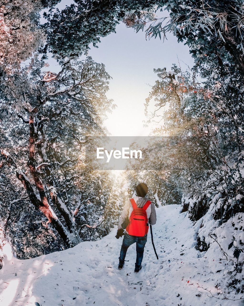 Rear view of man on snow covered field against sky