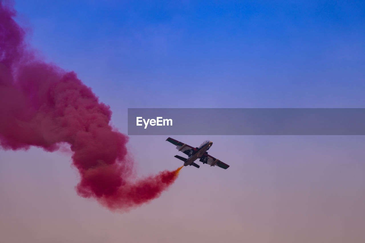 Low angle view of airplane in mid-air against sky