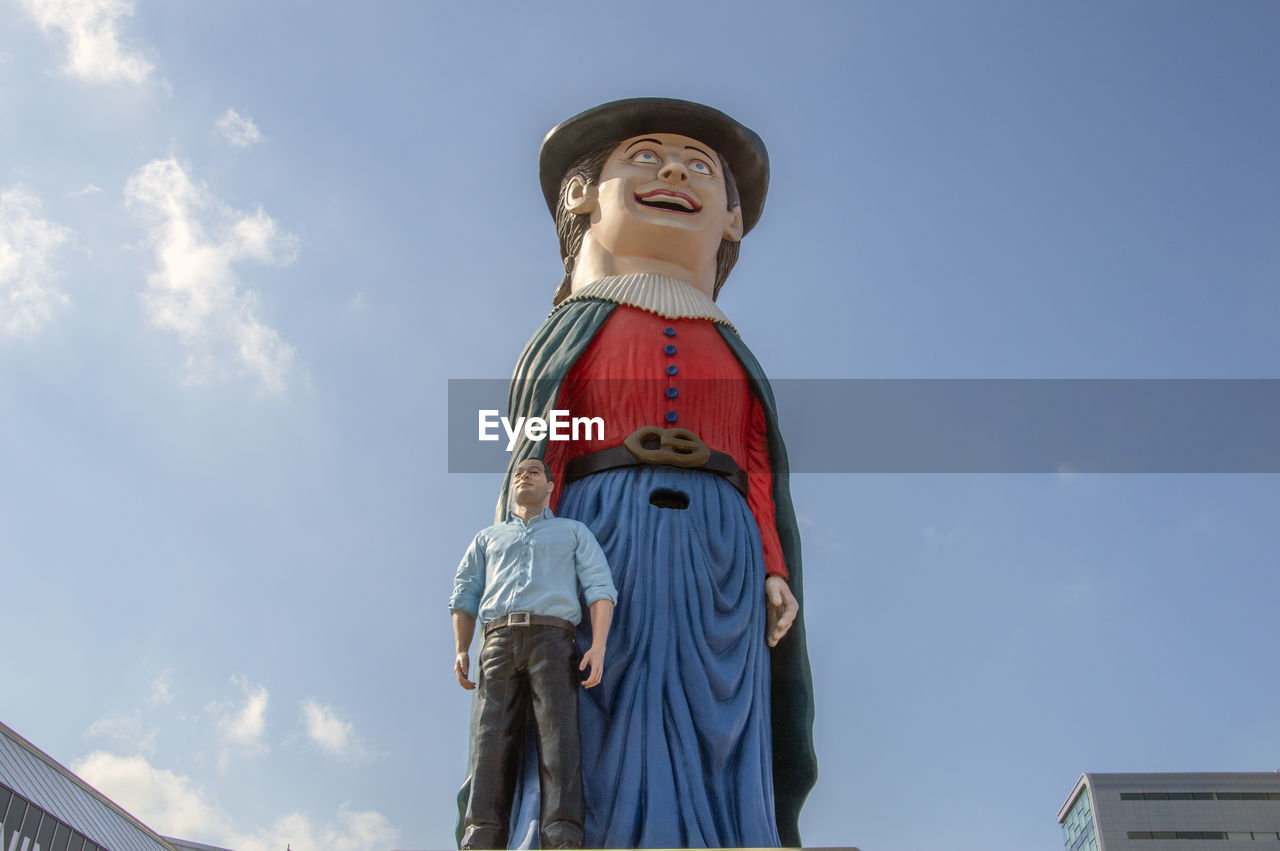 Low angle view of statues against blue sky