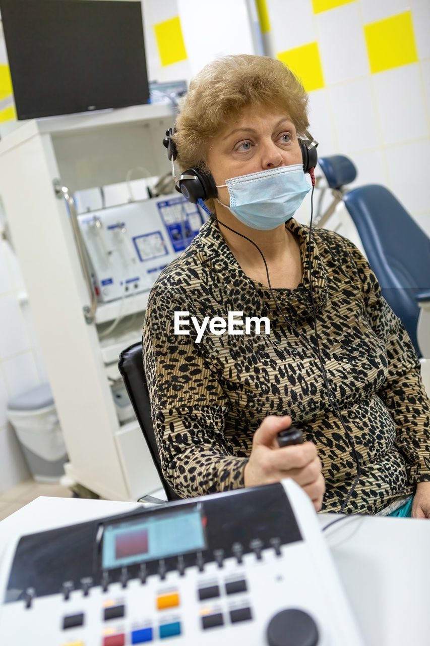 Audiologist checks the hearing of an older woman