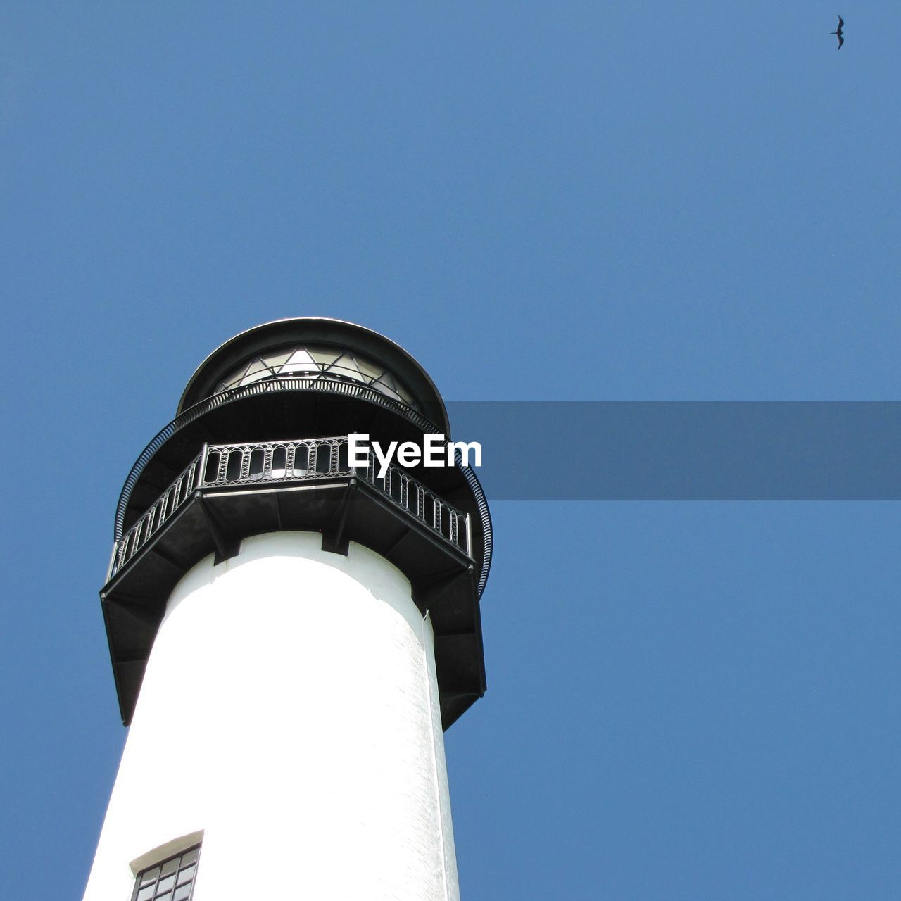 Low angle view of water tower against clear blue sky