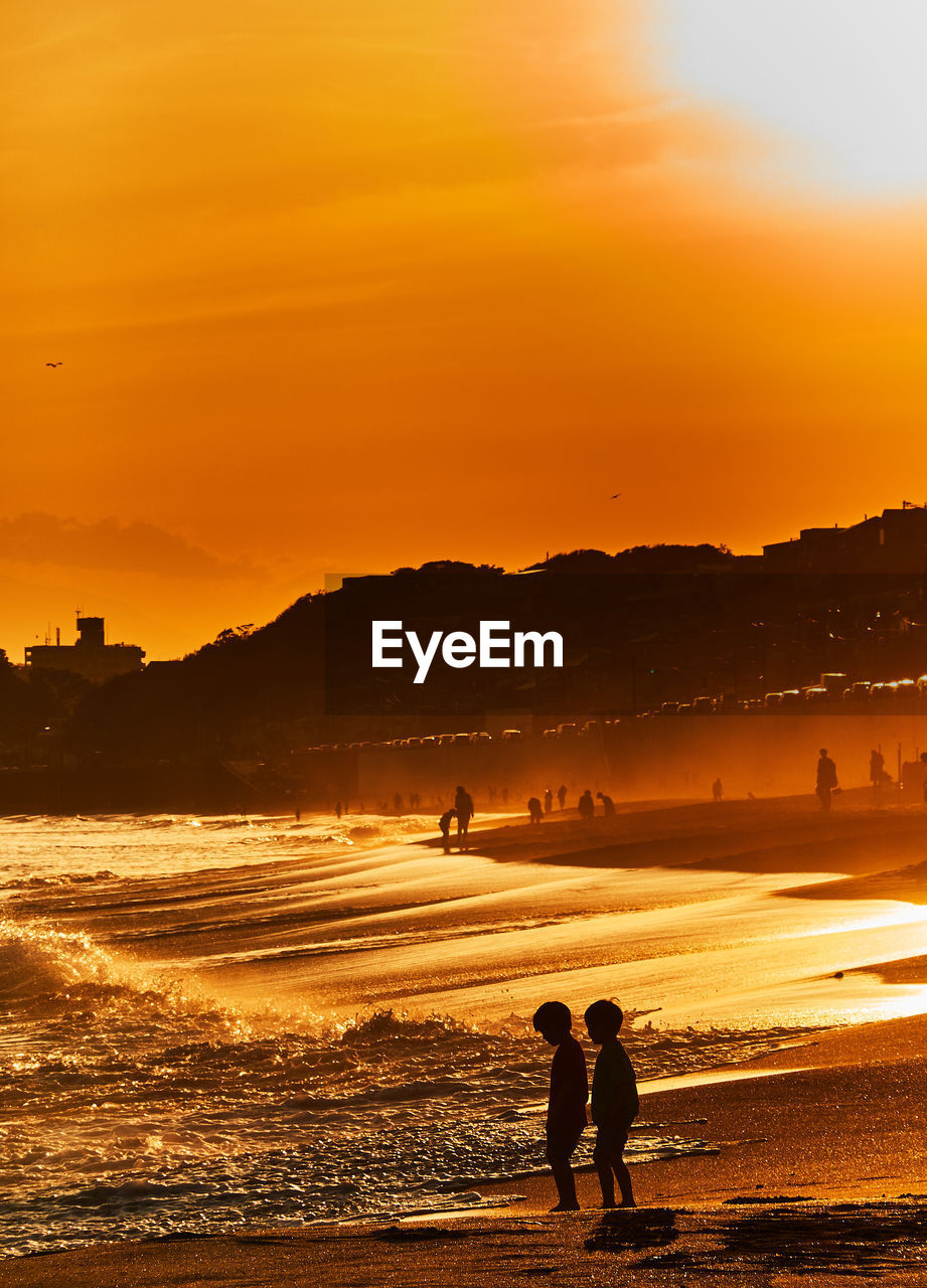 Silhouette of people at beach during sunset