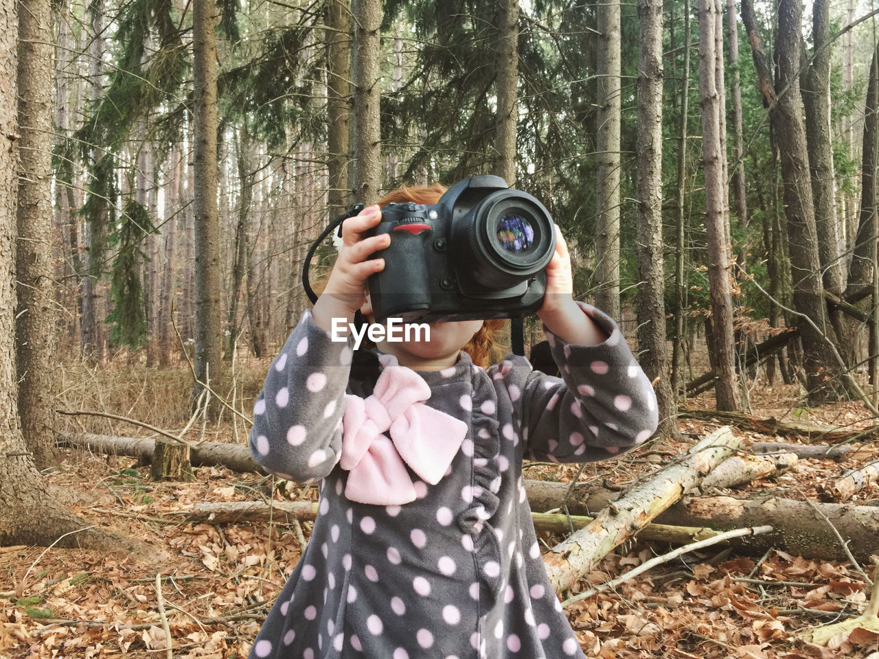 Girl photographing in forest