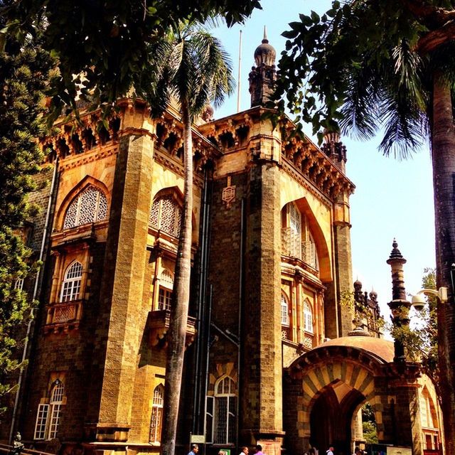 LOW ANGLE VIEW OF BUILT STRUCTURE WITH TREES IN BACKGROUND