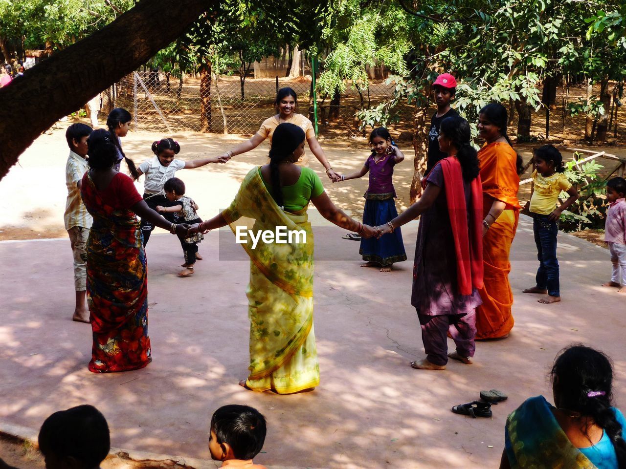 Group of people holding hands while playing in park