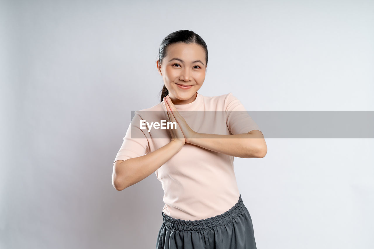 one person, studio shot, portrait, women, smiling, indoors, adult, looking at camera, clothing, happiness, emotion, standing, young adult, sleeve, female, copy space, front view, gray, photo shoot, lifestyles, arm, gray background, waist up, white background, exercising, cheerful, person, dancing, hand, positive emotion, vitality, skirt