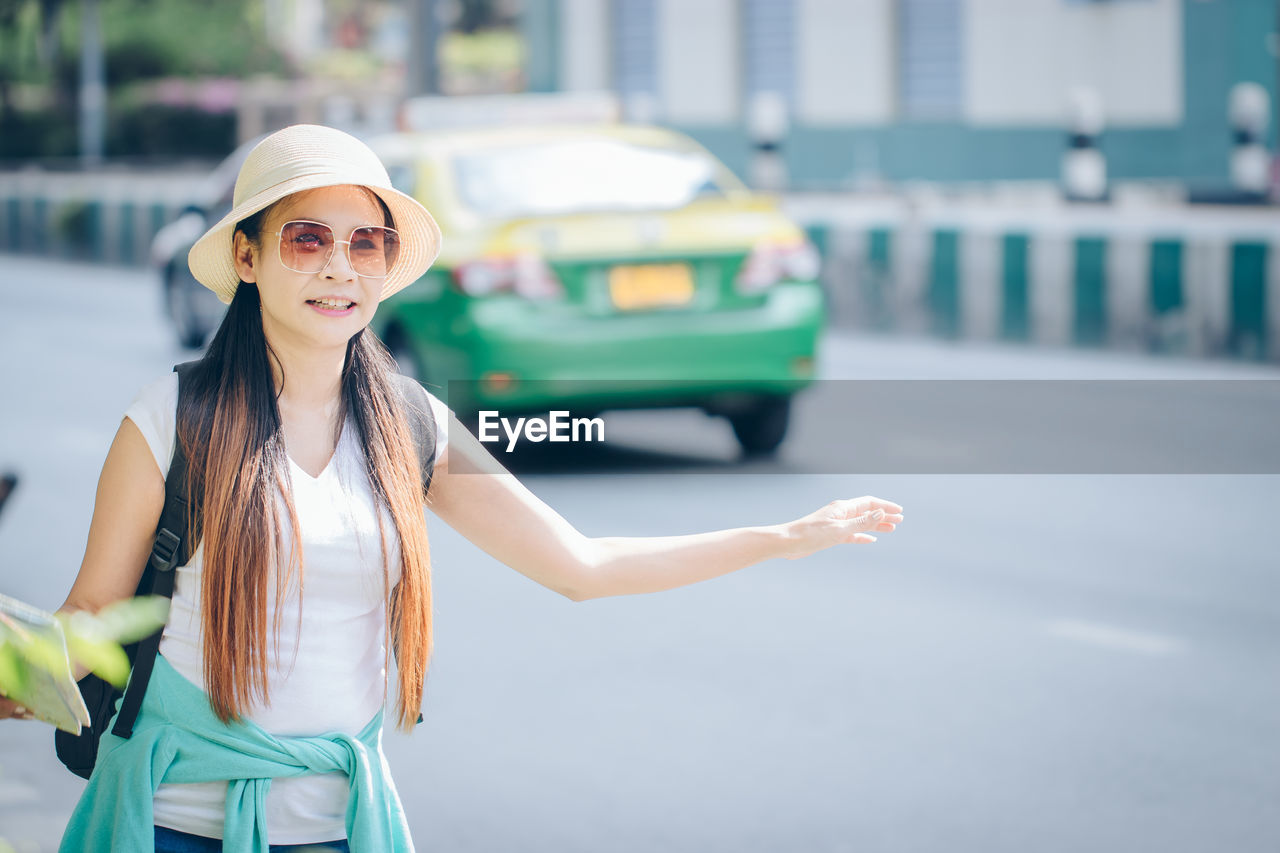 Woman hitchhiking on road