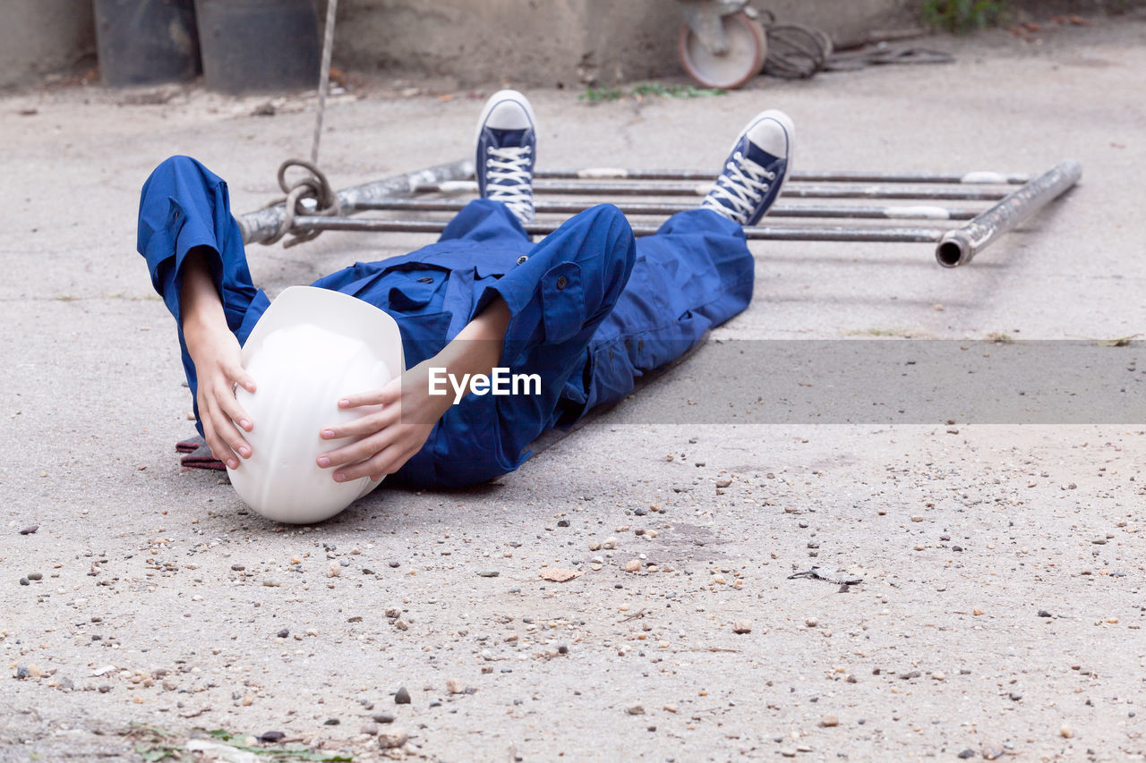 HIGH ANGLE VIEW OF BOY RELAXING ON STREET