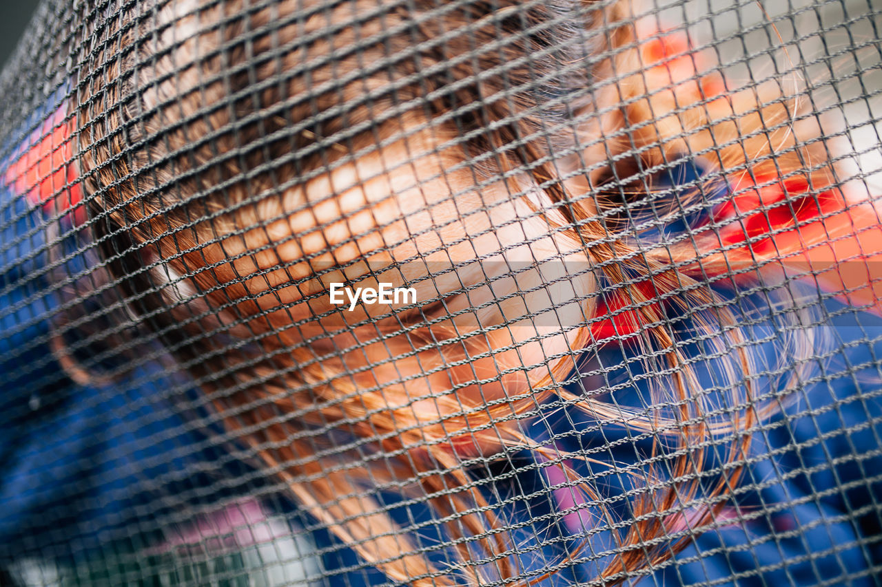 Close-up of girl seen through net