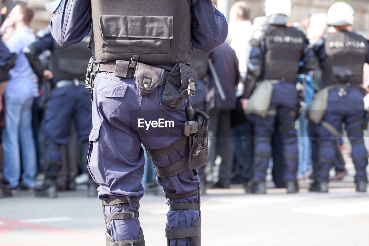 Rear view of police standing on street