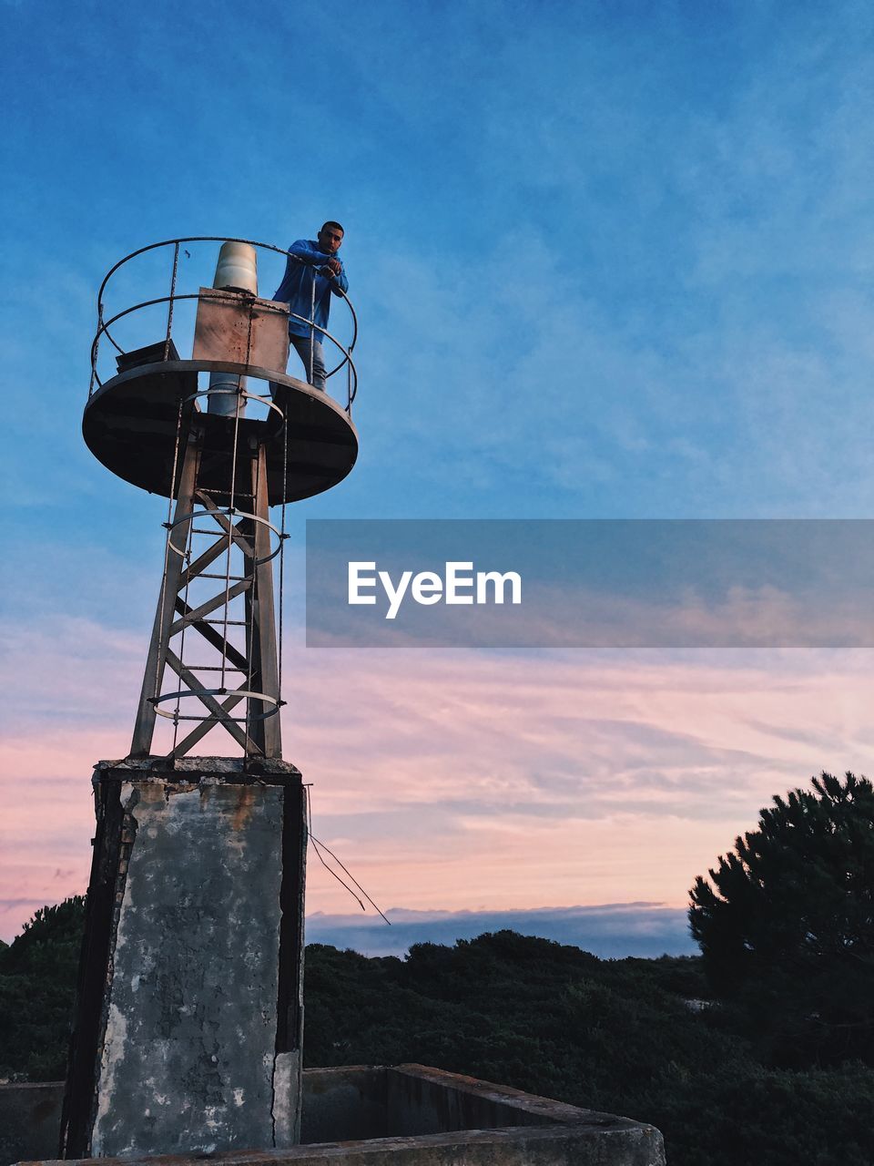 Low angle view of water tower against sky during sunset