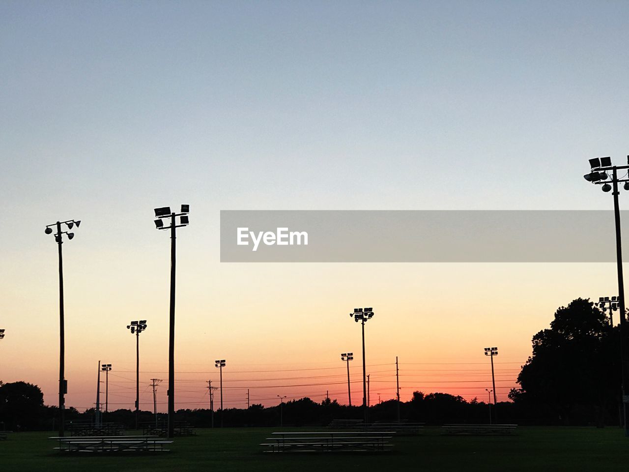 Street lights against clear sky during sunset