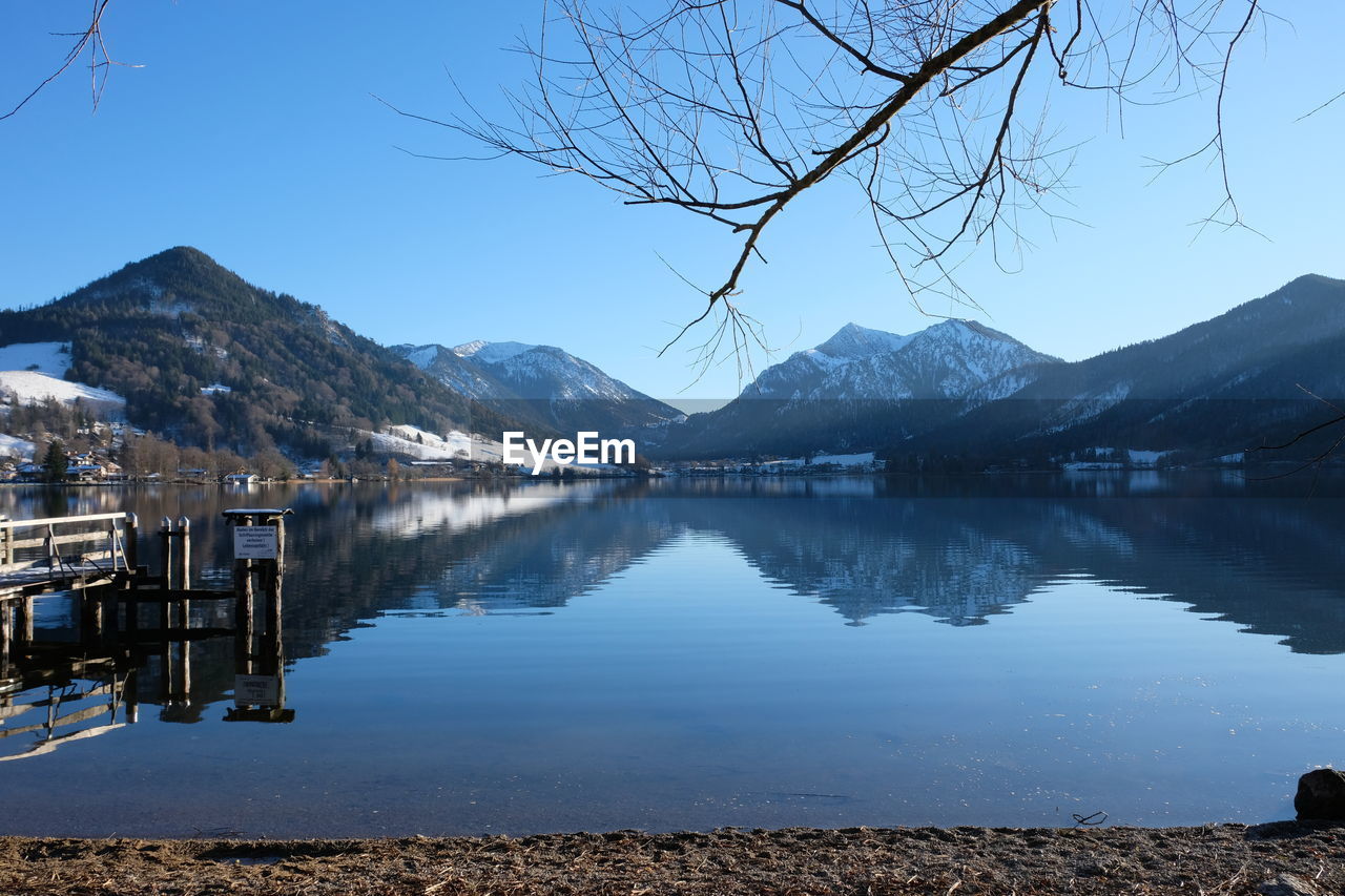 Scenic view of lake by mountains against clear sky