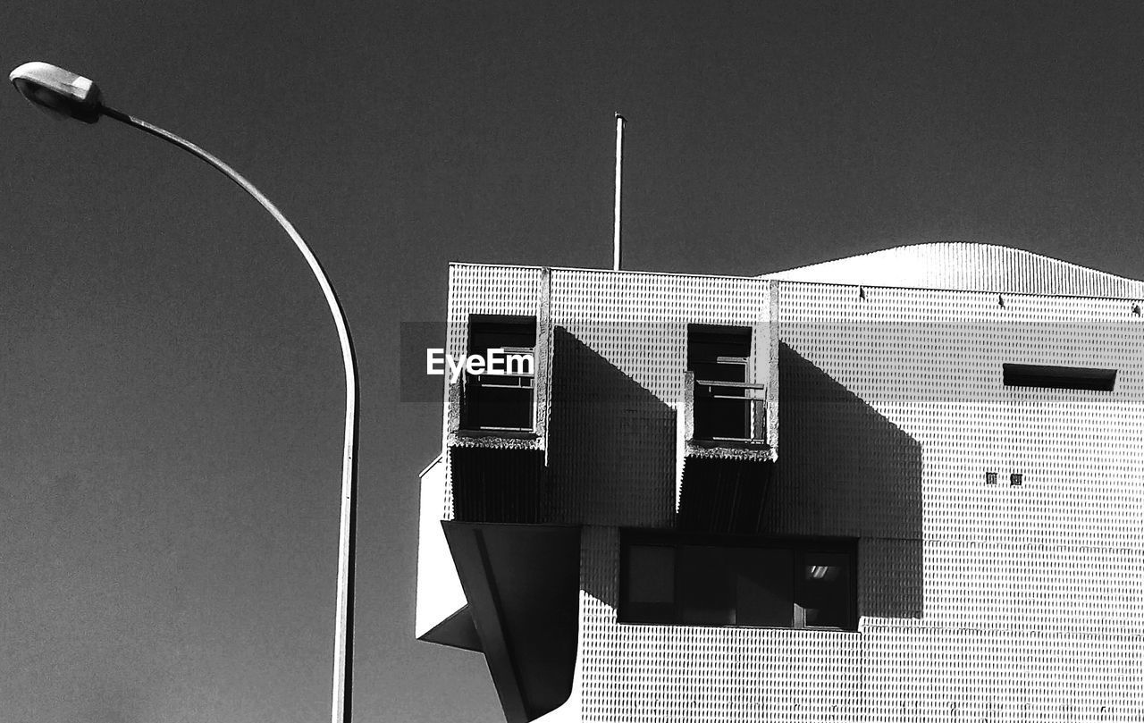 Low angle view of building by street light against clear sky