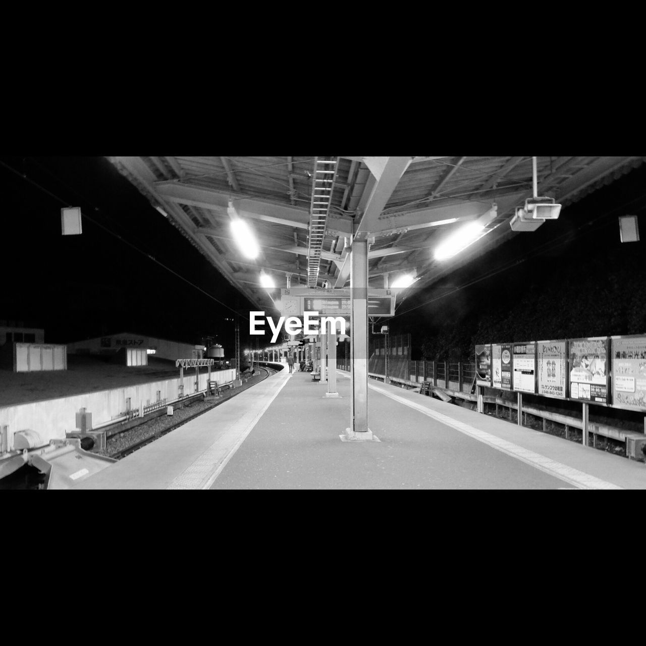 Empty illuminated railroad station platform at night