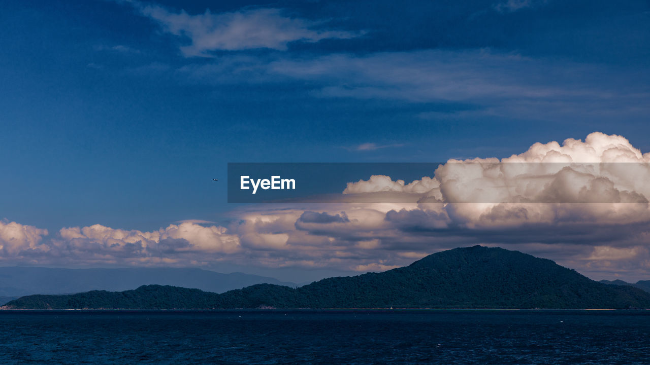 Scenic view of sea and mountains against sky