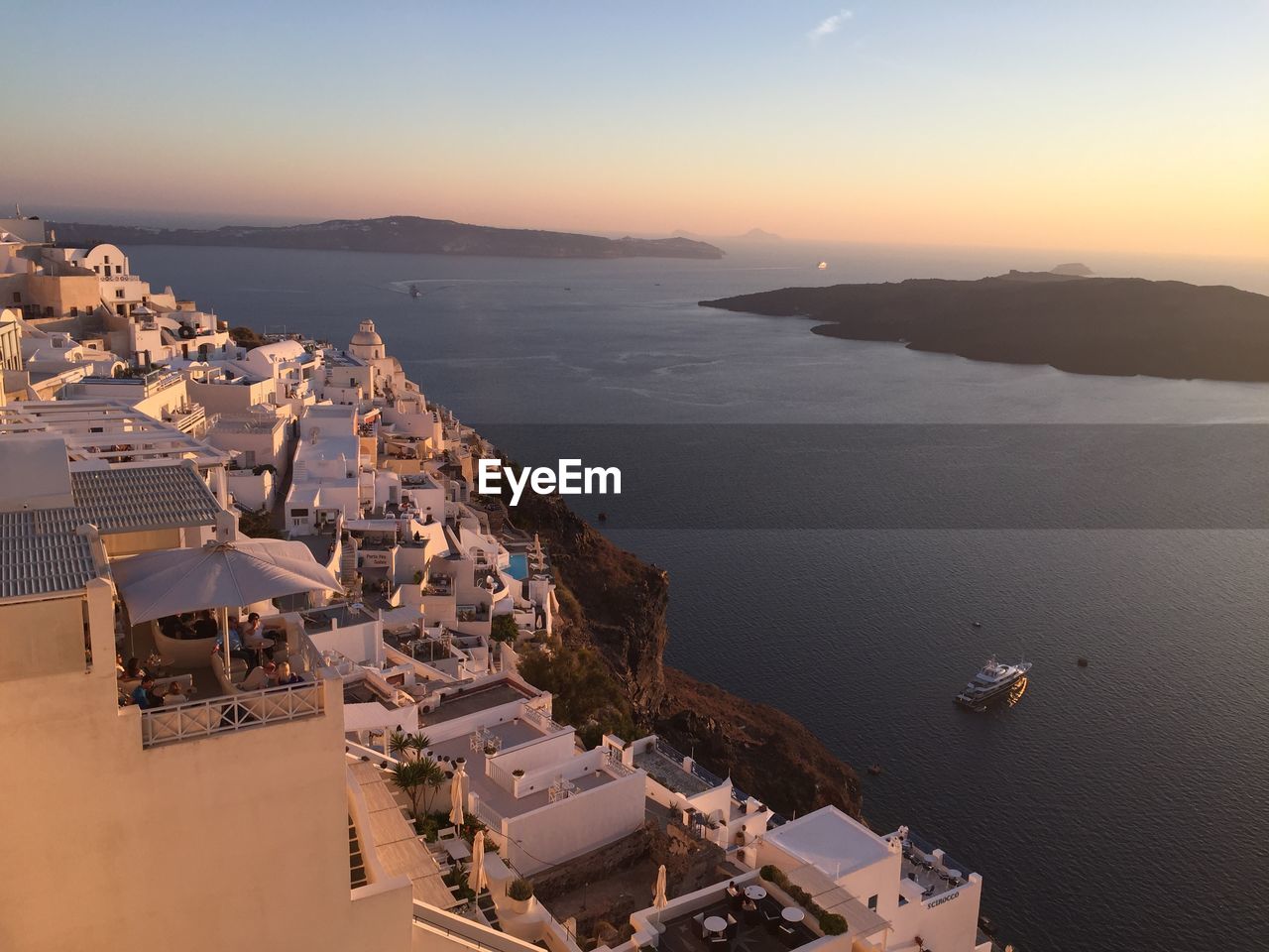 HIGH ANGLE VIEW OF CITY BY SEA AGAINST SKY