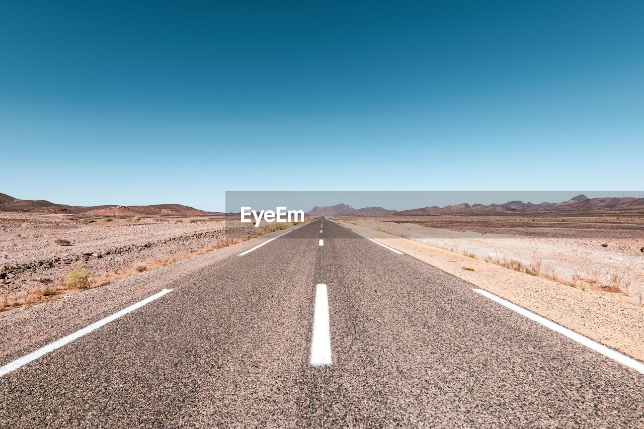 Scenic view of road against clear blue sky