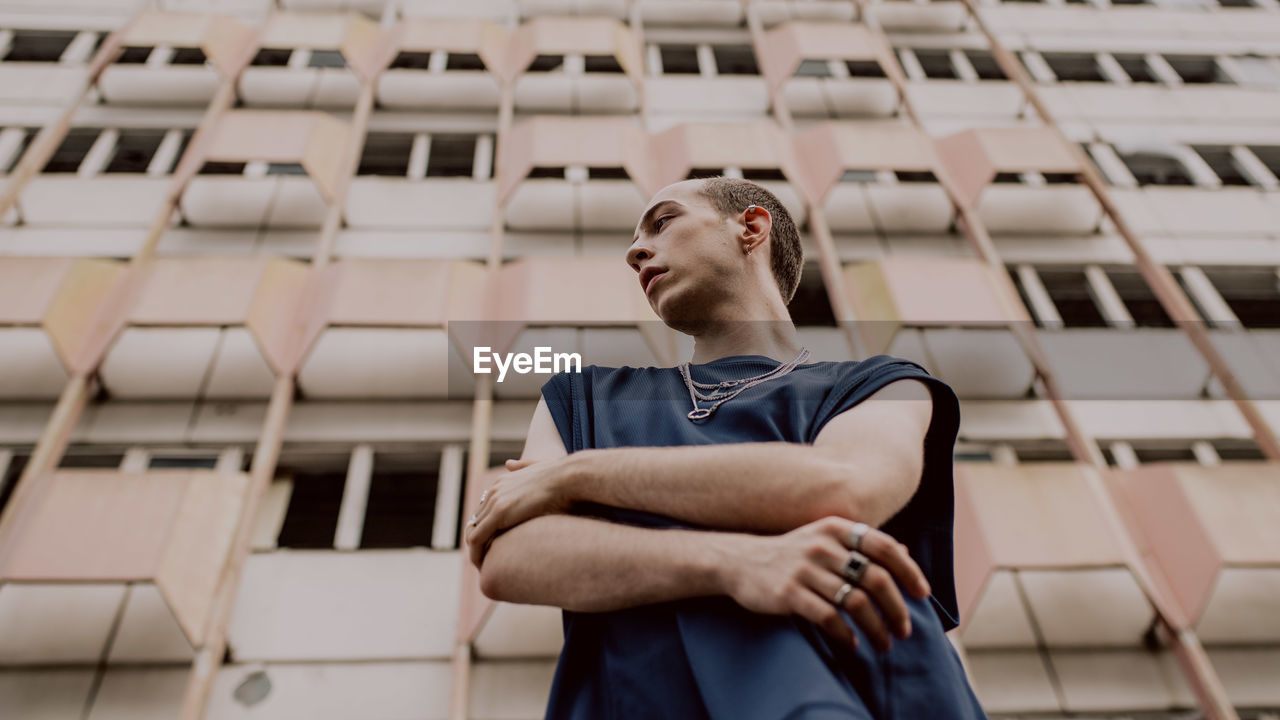 Low angle view of man standing against building in city 