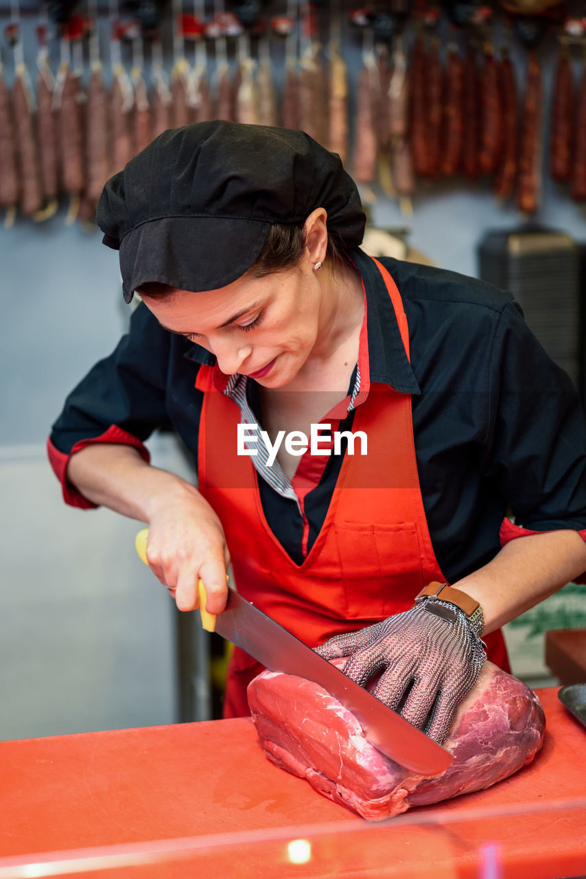 MIDSECTION OF MAN WORKING WITH MEAT