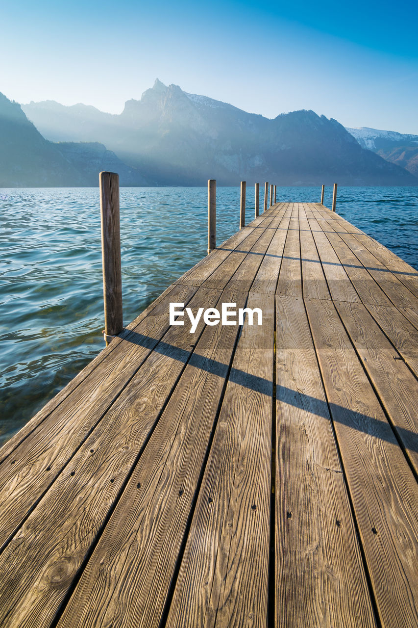 Wooden pier over sea against sky