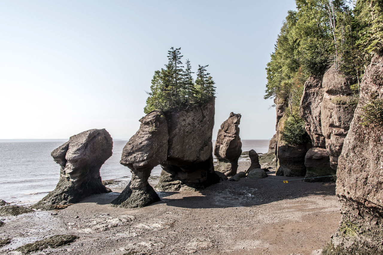 PANORAMIC SHOT OF ROCKS BY SEA AGAINST SKY