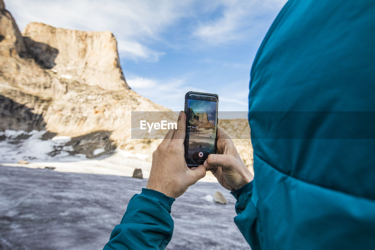 Climber takes photo of asgard mountain with his phone.