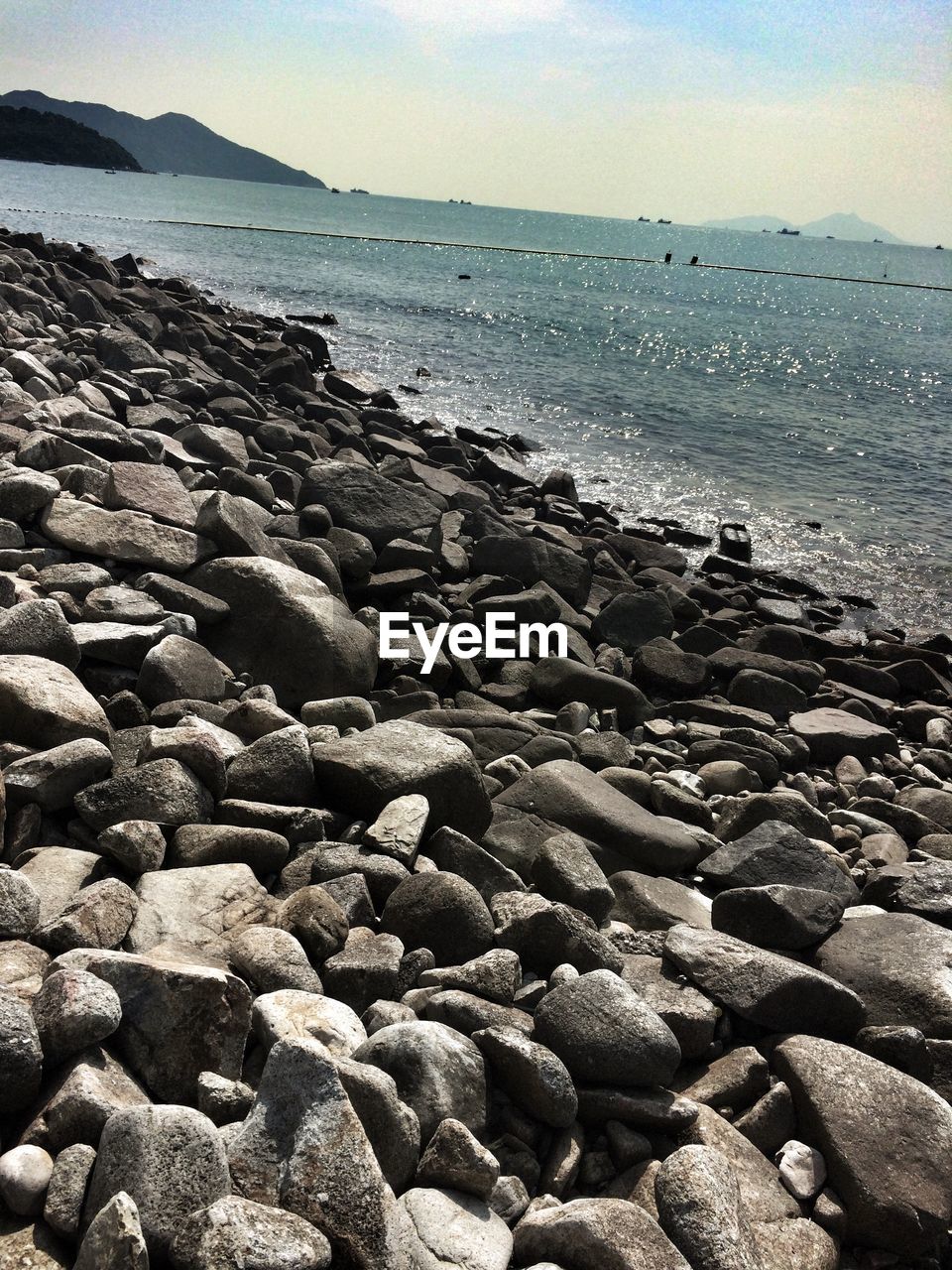 Rocky shore of sea against sky