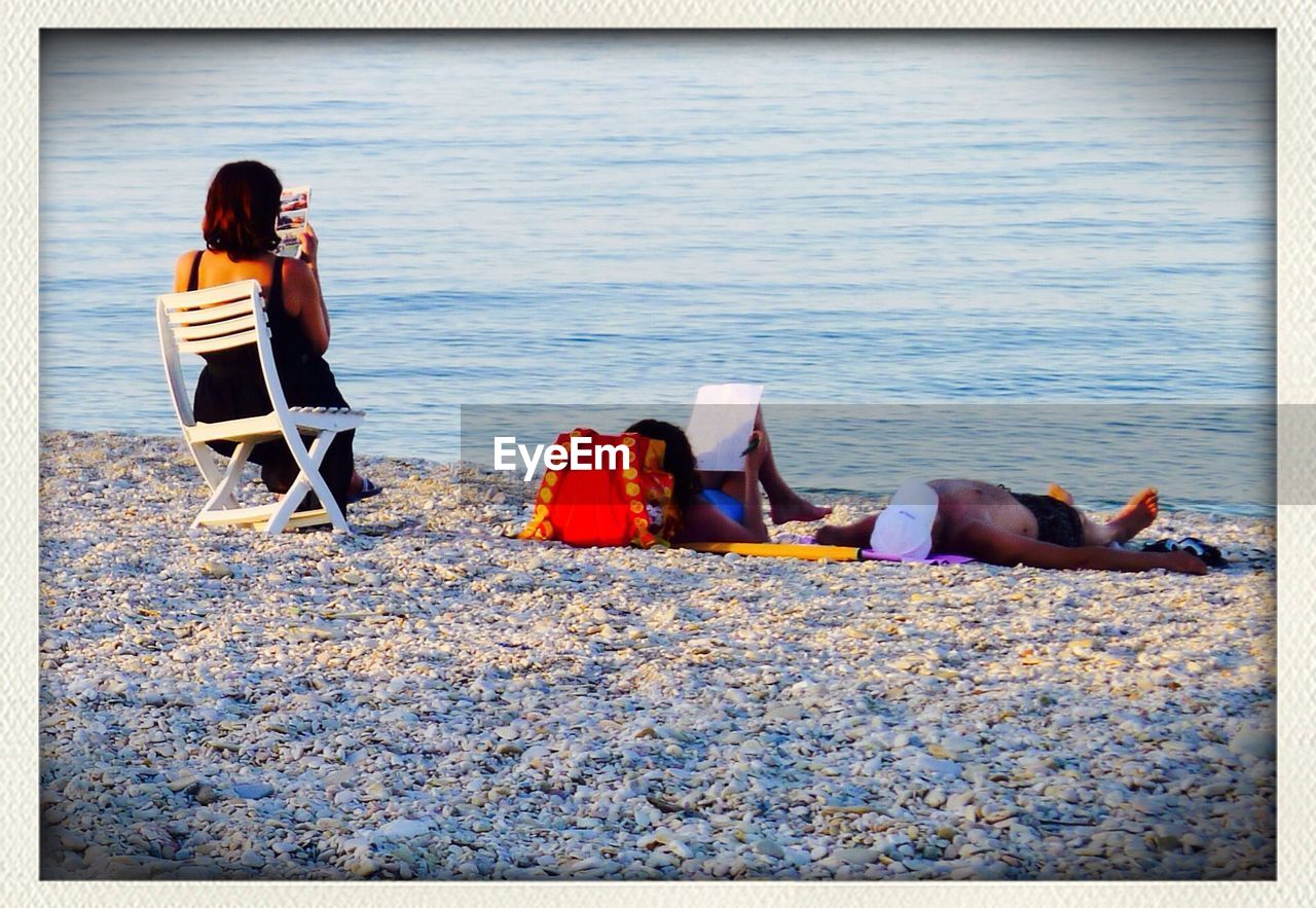 WOMAN SITTING ON SHORE