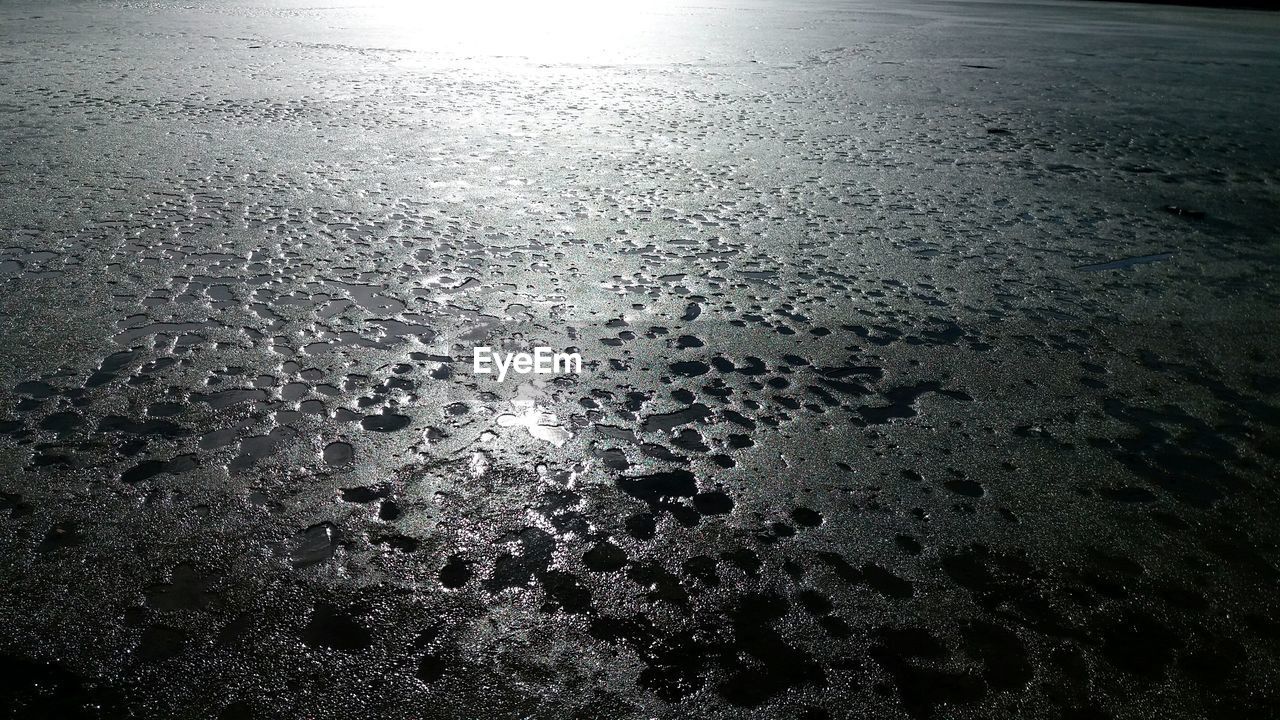 CLOSE-UP OF WET SAND ON BEACH