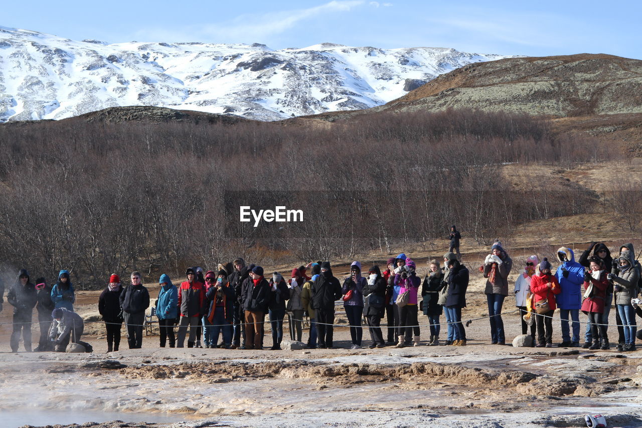 GROUP OF PEOPLE ON SNOWCAPPED MOUNTAIN AGAINST SKY