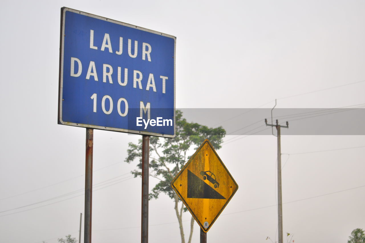 Low angle view of road sign against clear sky