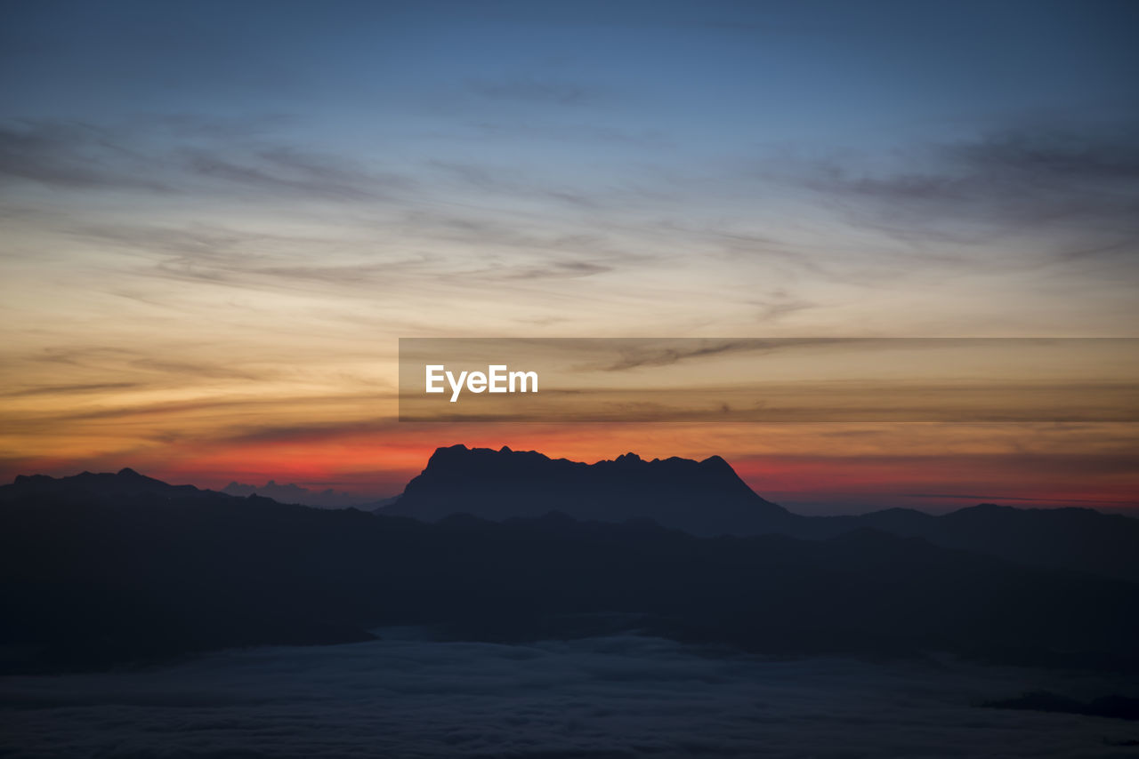 SCENIC VIEW OF SILHOUETTE MOUNTAINS AGAINST ROMANTIC SKY