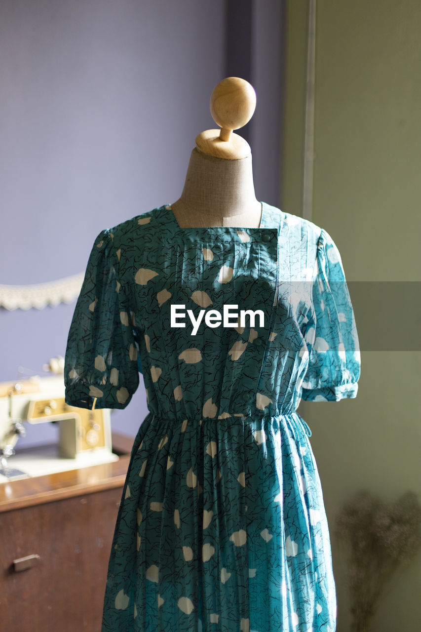 Green summer dress in mannequin.