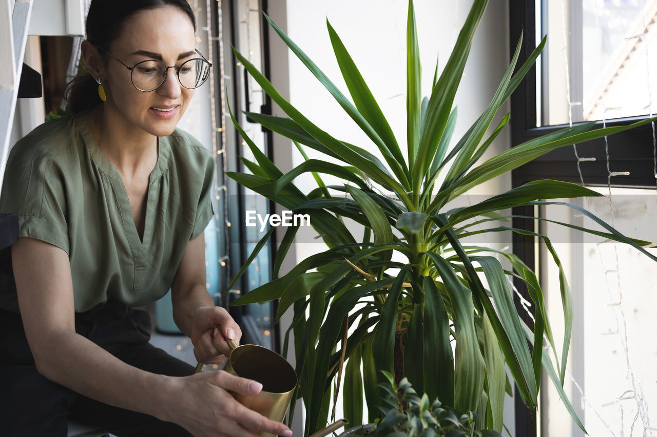 Florist woman watering and touching plants