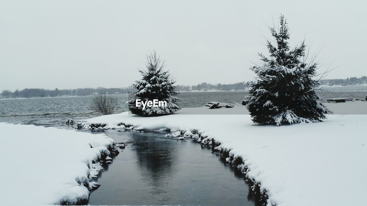 Scenic view of lake against sky during winter