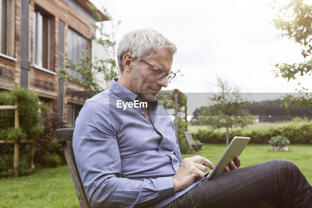 Mature man using digital tablet in garden