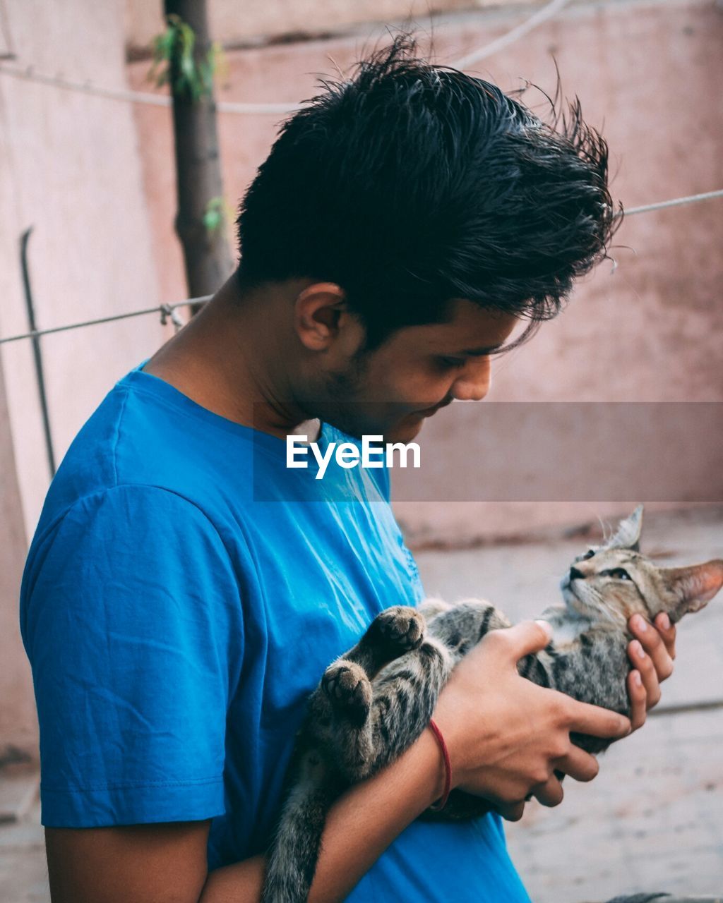 Young man holding cat