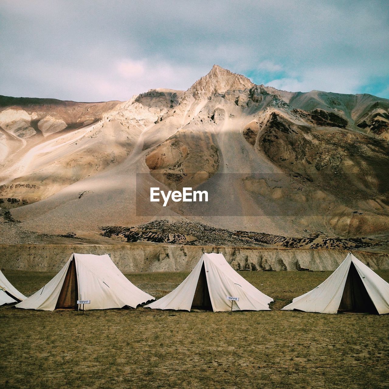 View of tents on field with mountains in background