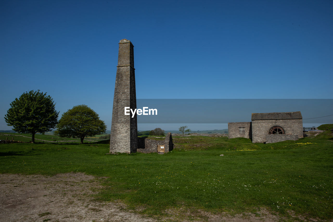 OLD CASTLE ON FIELD AGAINST CLEAR BLUE SKY