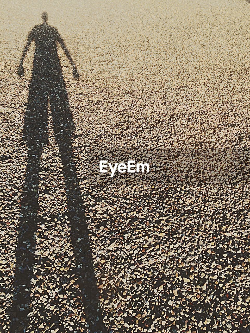 Shadow of man on pebbles