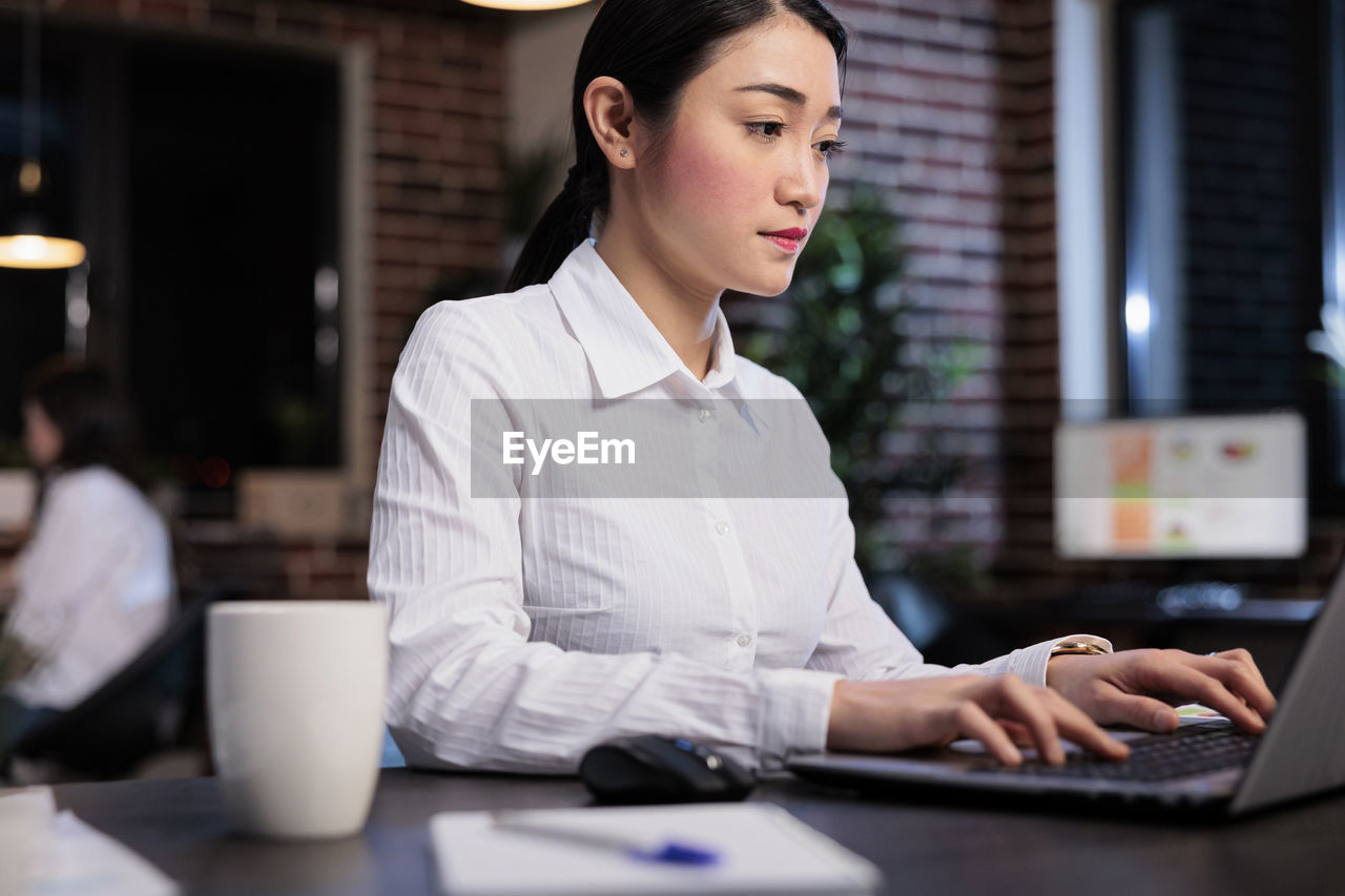 Businesswoman using laptop at office