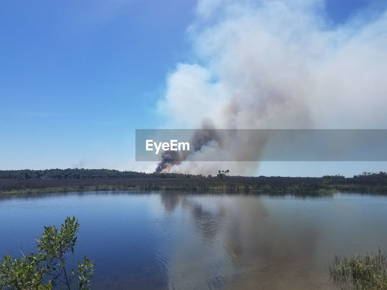 PANORAMIC VIEW OF PEOPLE ON LAKE AGAINST SKY