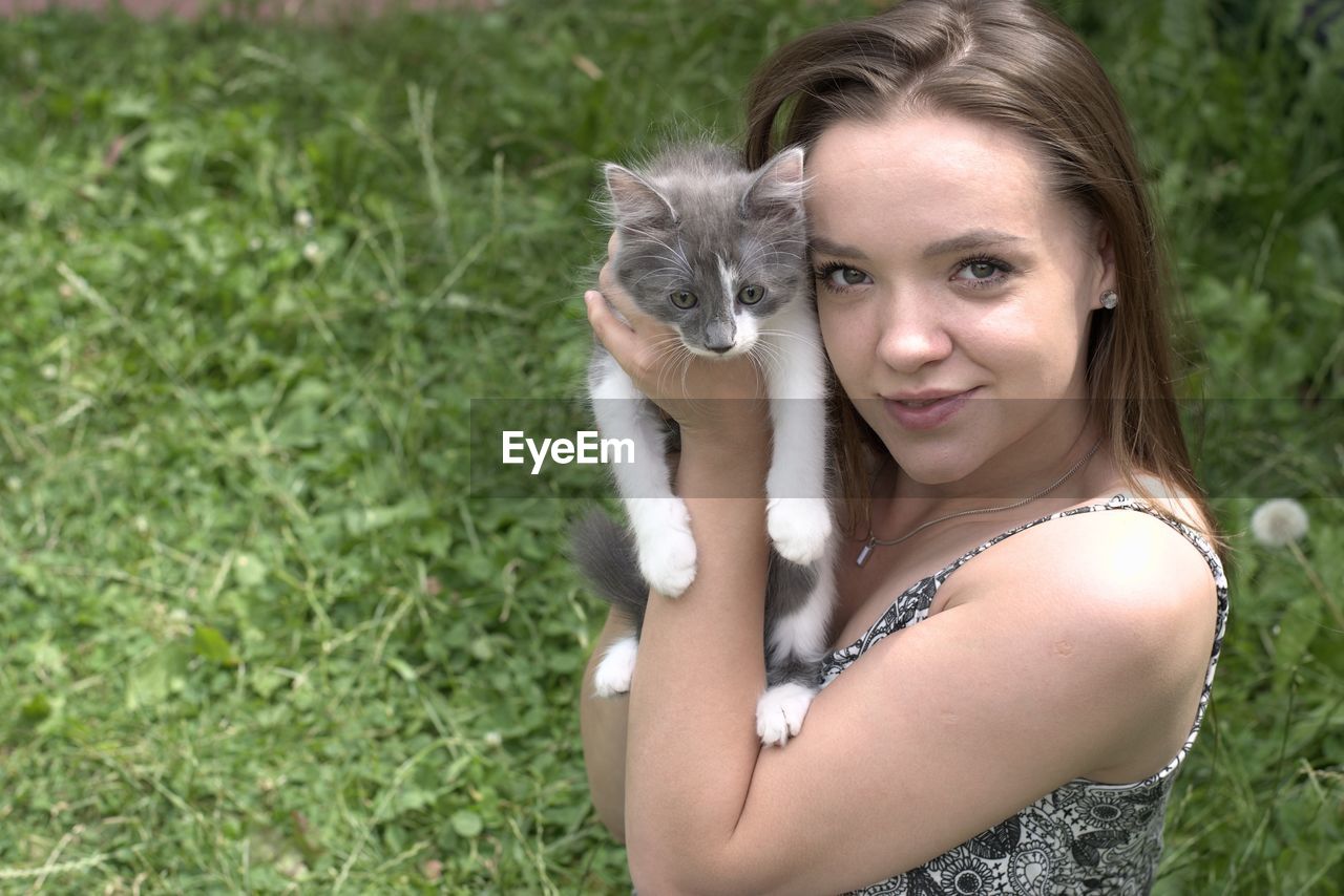 Portrait of smiling young woman holding cat