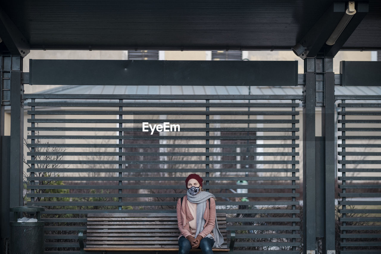 Woman with face mask waiting for public transportation