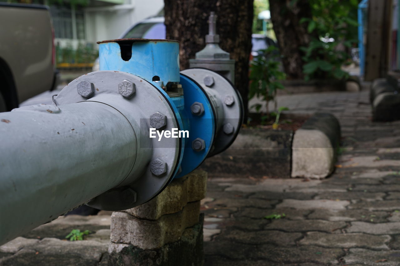 CLOSE-UP OF OLD MACHINE PART ON FOOTPATH