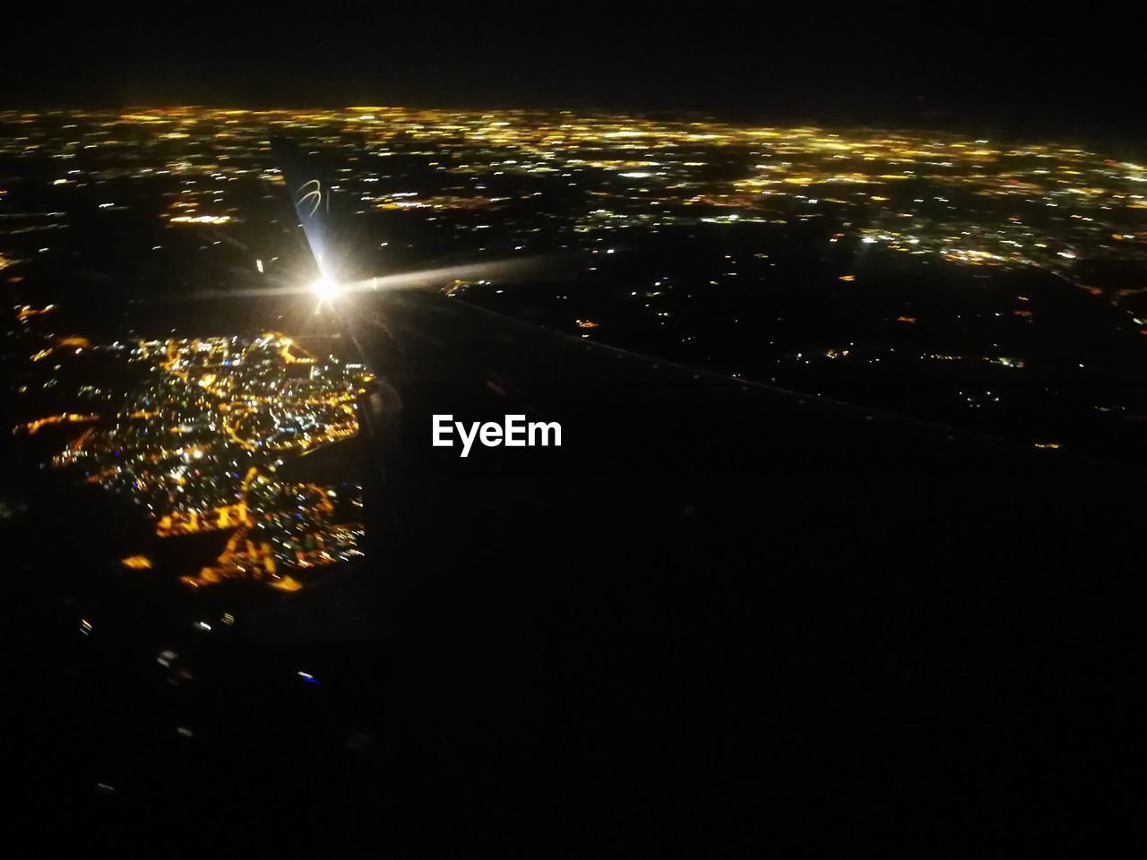 HIGH ANGLE VIEW OF ILLUMINATED CITYSCAPE AGAINST SKY