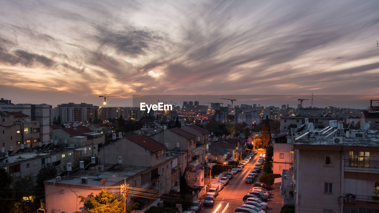 High angle view of illuminated cityscape against sky at sunset