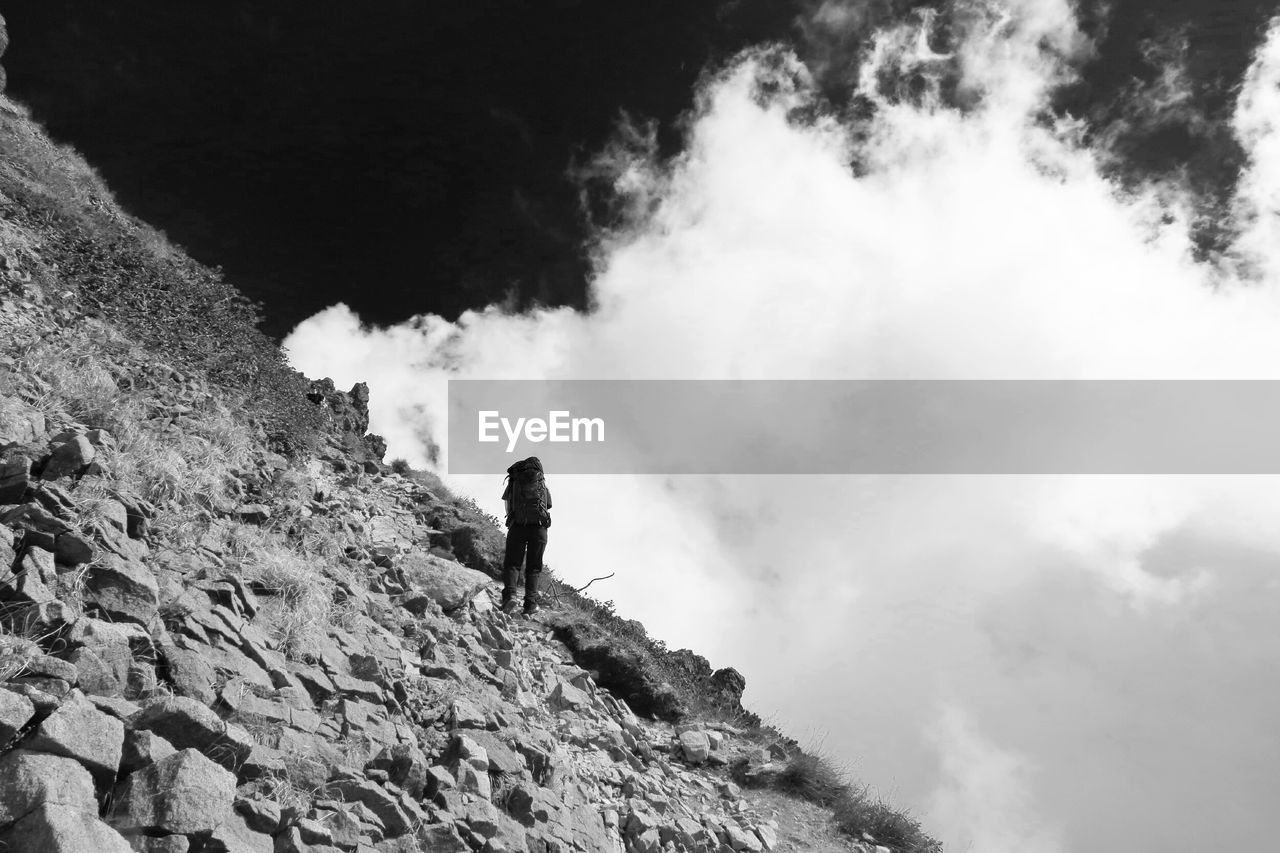 LOW ANGLE VIEW OF TOURISTS ON MOUNTAIN